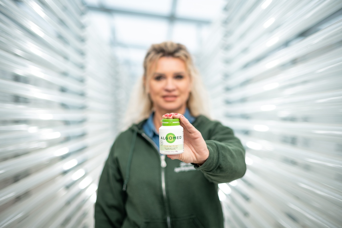 Katrin Beberhold hält ein Produkt in der Hand und zeigt es in die Kamera
